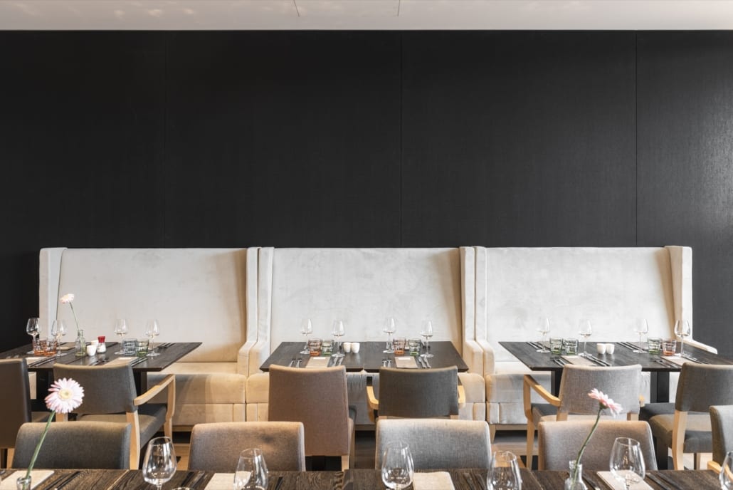 Tables joliment dressées avec panneaux muraux noirs dans le restaurant de l'hôtel Mercure